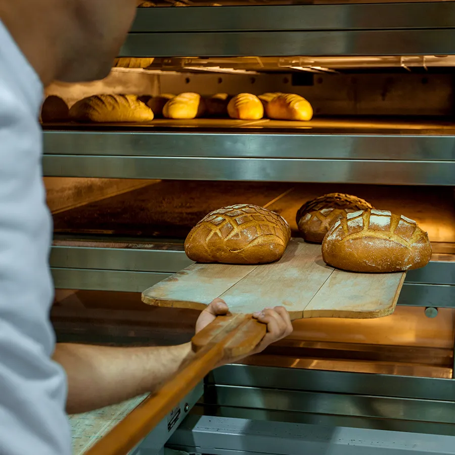 The stone deck oven at Archive Bakery, door open with loaves inside